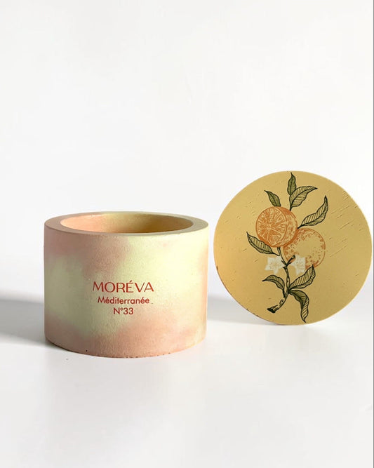 A concrete jar candle with a designer lid